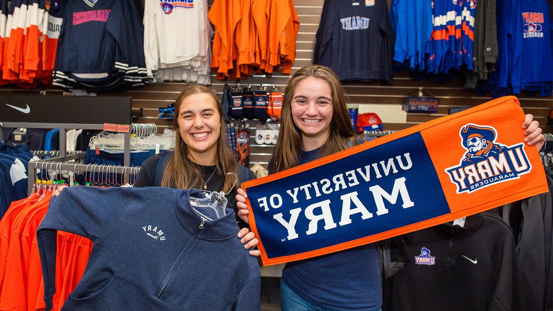 Students holding apparel in the bookstore